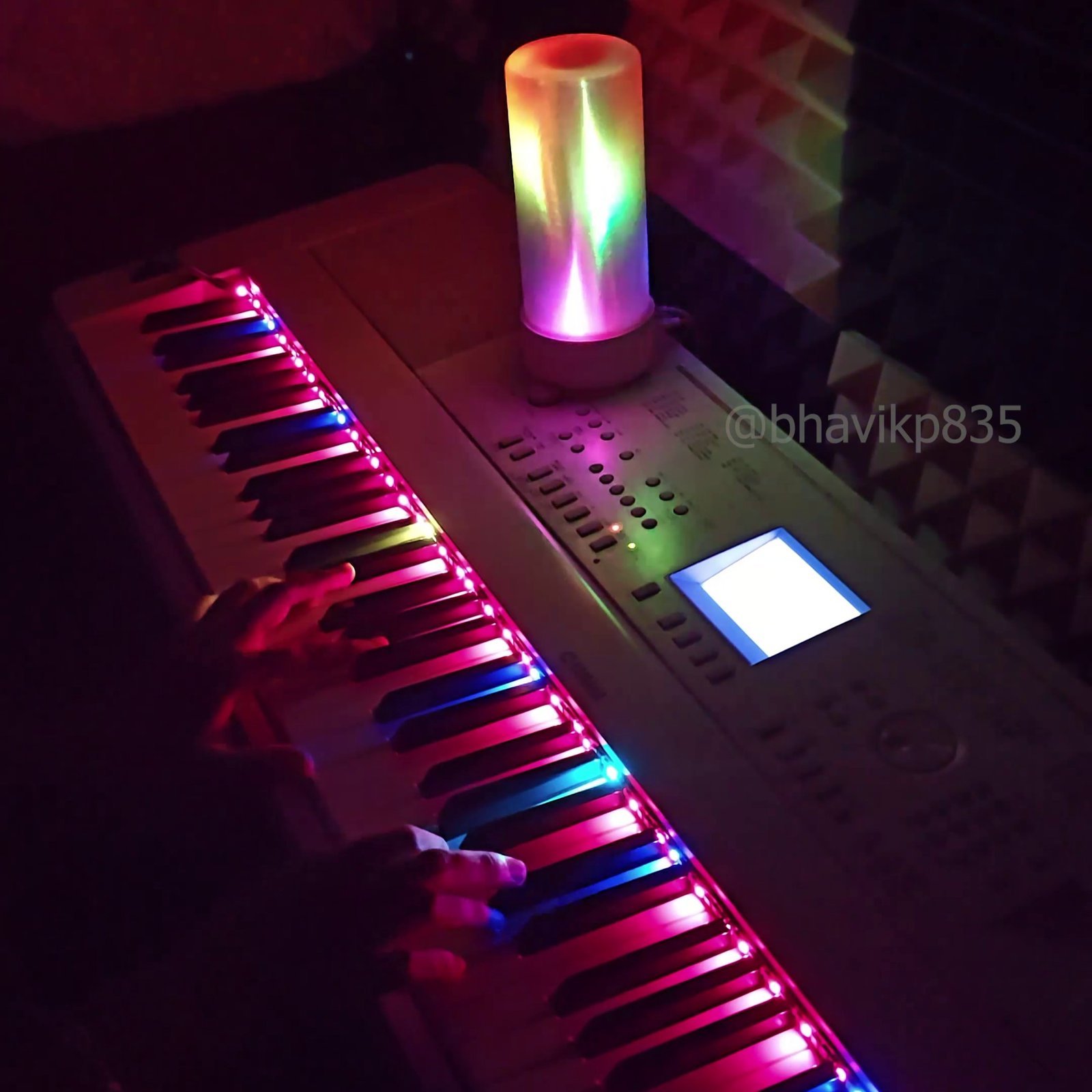 Helix lamp and piano LED strip glowing in a studio